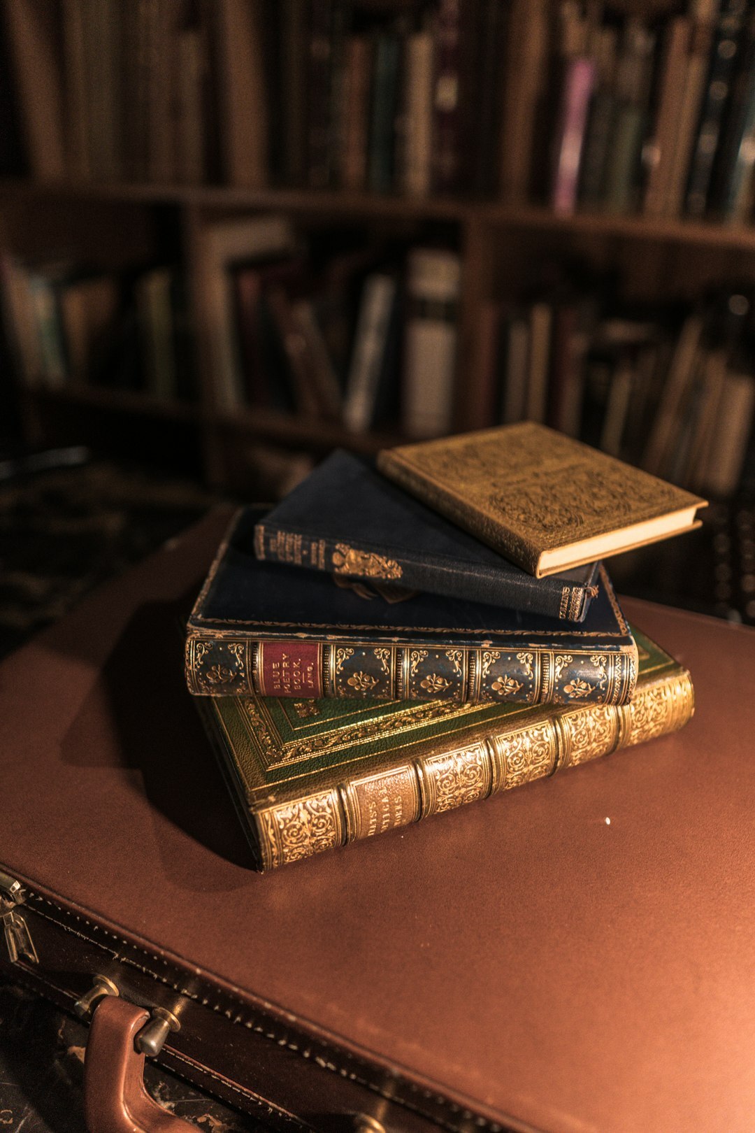 Stack of old leather bound books with a brass magnifying glass
