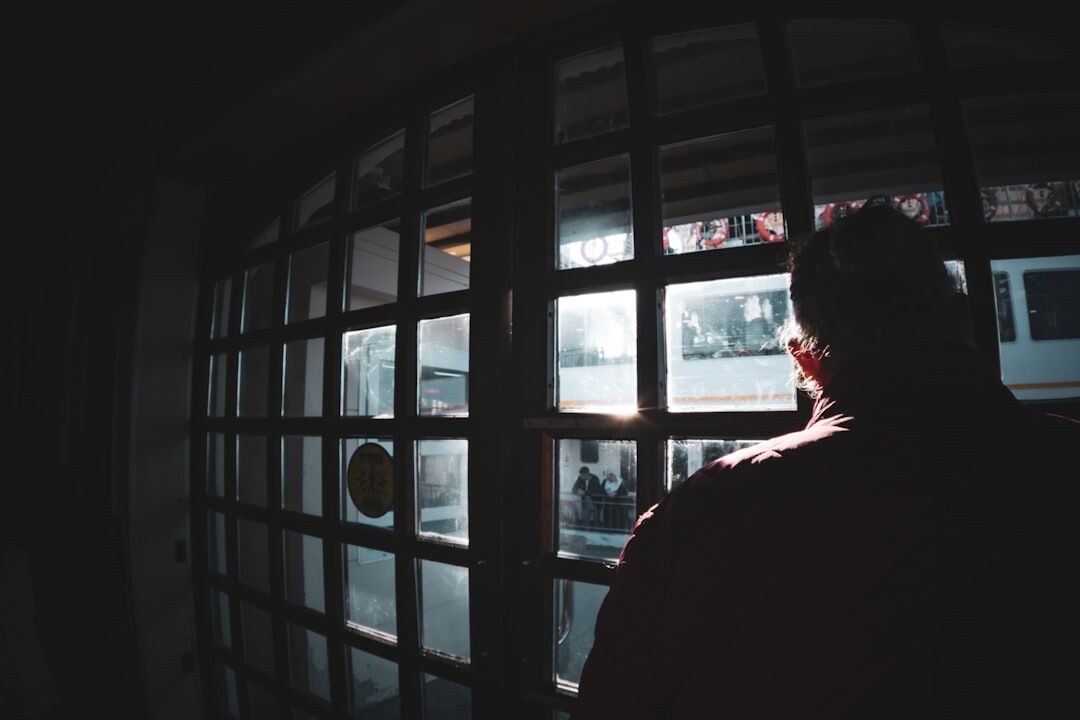 person looking through window at night